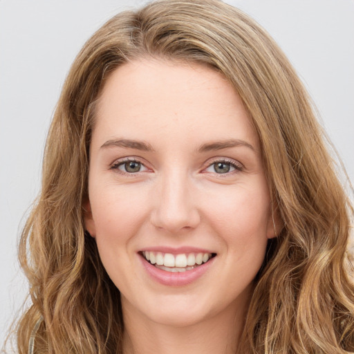 Joyful white young-adult female with long  brown hair and green eyes