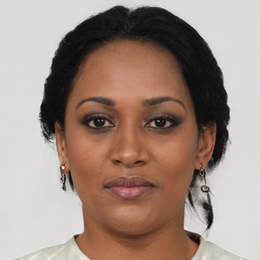 Joyful black adult female with short  black hair and brown eyes