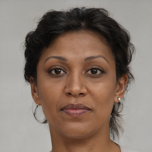 Joyful black adult female with medium  brown hair and brown eyes