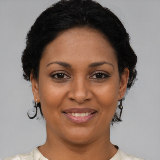 Joyful latino young-adult female with short  black hair and brown eyes