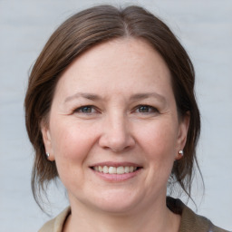 Joyful white adult female with medium  brown hair and grey eyes