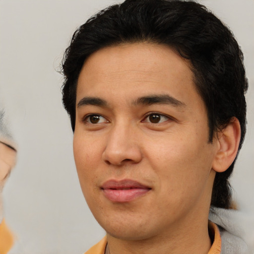 Joyful latino young-adult male with medium  brown hair and brown eyes