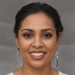 Joyful latino young-adult female with medium  brown hair and brown eyes