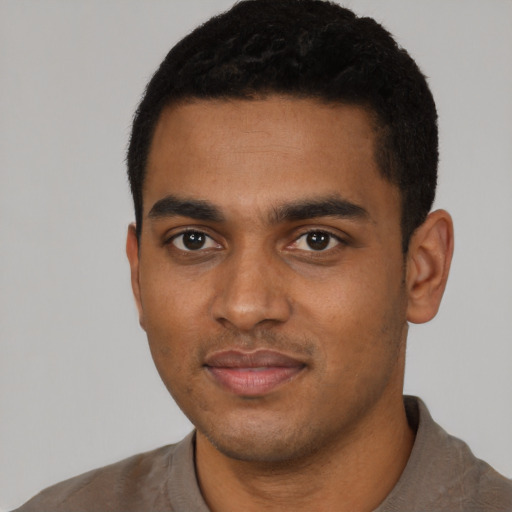 Joyful black young-adult male with short  black hair and brown eyes