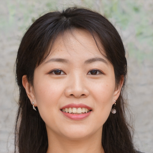 Joyful asian young-adult female with long  brown hair and brown eyes