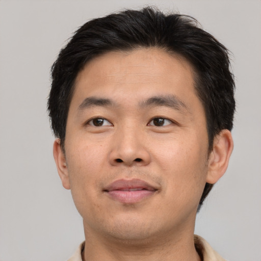 Joyful asian adult male with short  brown hair and brown eyes
