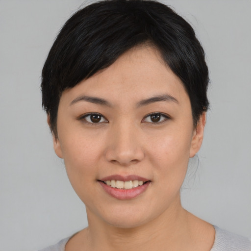 Joyful asian young-adult female with short  black hair and brown eyes