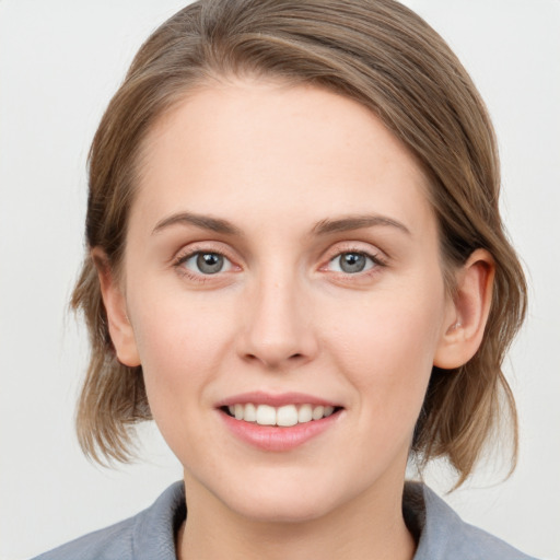 Joyful white young-adult female with medium  brown hair and blue eyes