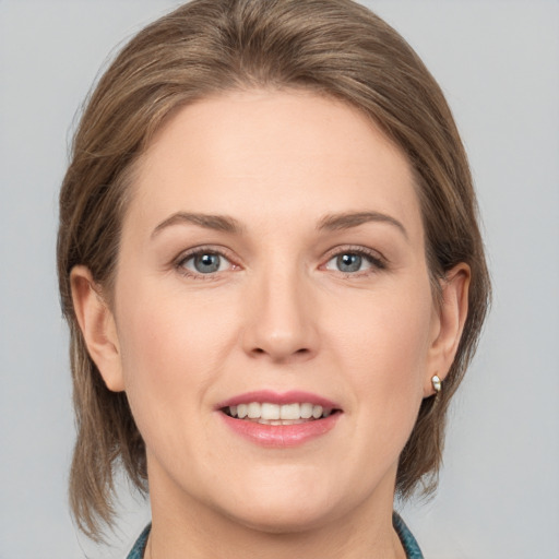 Joyful white young-adult female with medium  brown hair and grey eyes