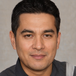 Joyful white adult male with short  black hair and brown eyes