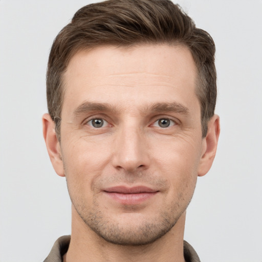 Joyful white young-adult male with short  brown hair and grey eyes