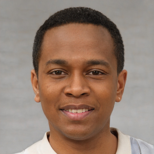 Joyful black young-adult male with short  black hair and brown eyes
