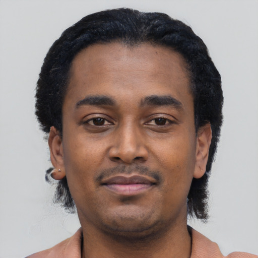 Joyful black young-adult male with short  black hair and brown eyes