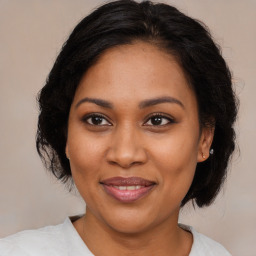 Joyful black adult female with medium  brown hair and brown eyes