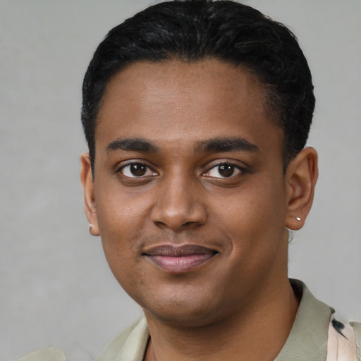 Joyful black young-adult male with short  black hair and brown eyes