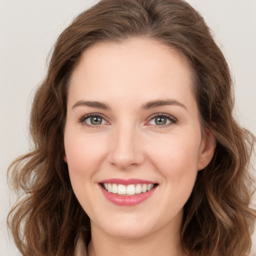 Joyful white young-adult female with long  brown hair and green eyes