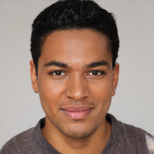 Joyful black young-adult male with short  black hair and brown eyes