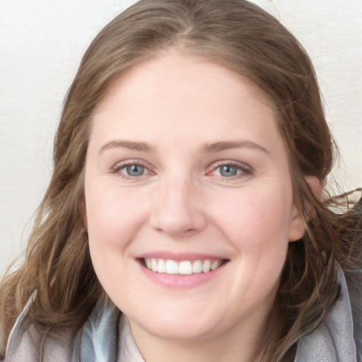 Joyful white young-adult female with long  brown hair and blue eyes