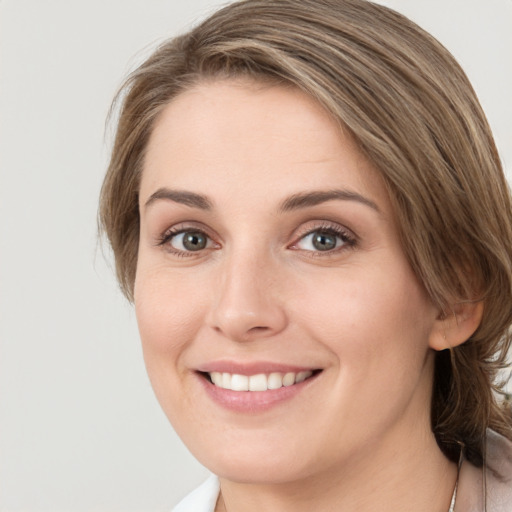 Joyful white young-adult female with medium  brown hair and green eyes