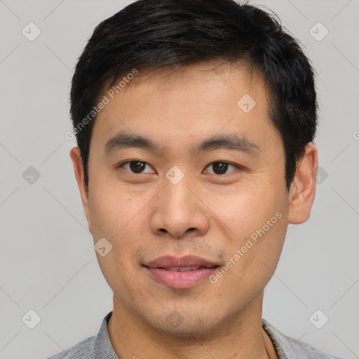 Joyful asian young-adult male with short  black hair and brown eyes