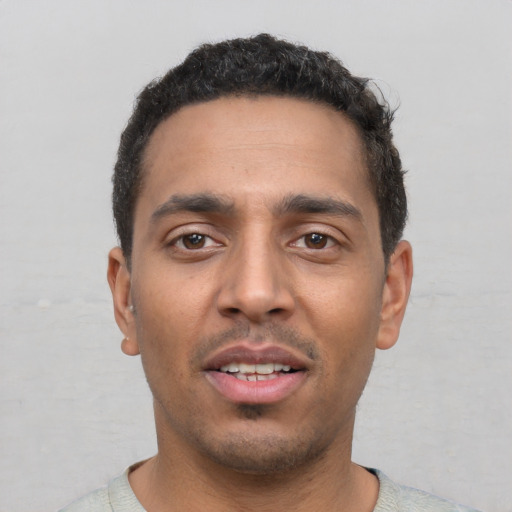 Joyful white young-adult male with short  black hair and brown eyes