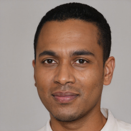 Joyful black young-adult male with short  black hair and brown eyes