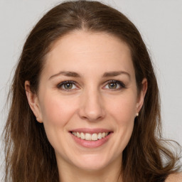 Joyful white young-adult female with long  brown hair and grey eyes