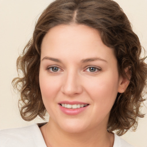 Joyful white young-adult female with medium  brown hair and green eyes