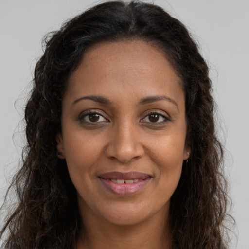 Joyful black young-adult female with long  brown hair and brown eyes