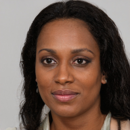 Joyful black young-adult female with long  brown hair and brown eyes
