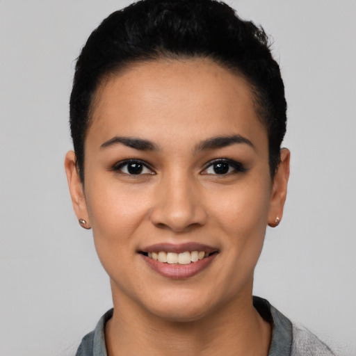 Joyful latino young-adult female with short  black hair and brown eyes