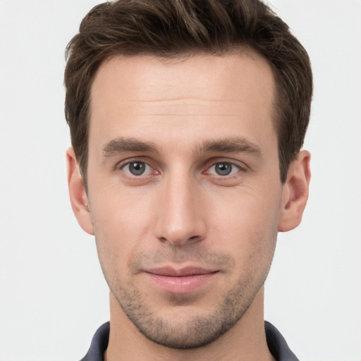 Joyful white young-adult male with short  brown hair and grey eyes