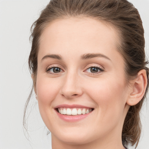 Joyful white young-adult female with long  brown hair and green eyes