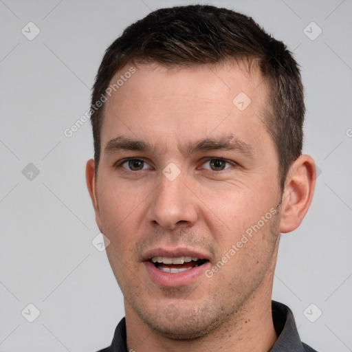 Joyful white young-adult male with short  brown hair and grey eyes