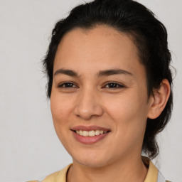 Joyful latino young-adult female with medium  brown hair and brown eyes