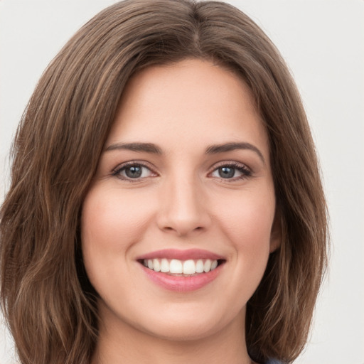 Joyful white young-adult female with long  brown hair and green eyes