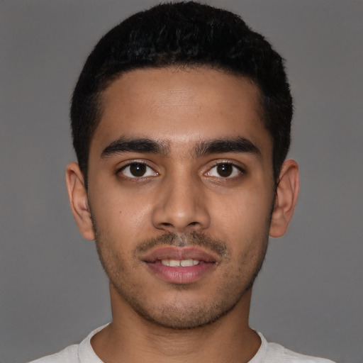 Joyful latino young-adult male with short  brown hair and brown eyes