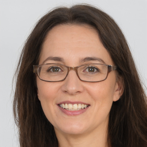 Joyful white adult female with long  brown hair and grey eyes