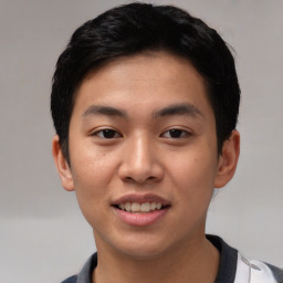 Joyful asian young-adult male with short  black hair and brown eyes