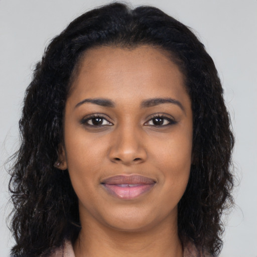 Joyful black young-adult female with long  black hair and brown eyes