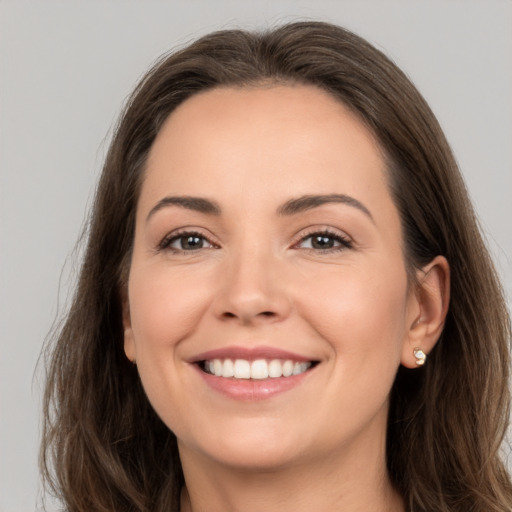 Joyful white young-adult female with long  brown hair and brown eyes