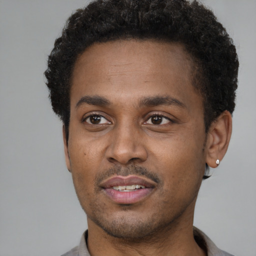Joyful latino young-adult male with short  brown hair and brown eyes