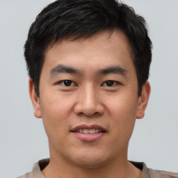 Joyful asian young-adult male with short  brown hair and brown eyes