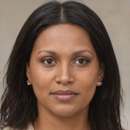 Joyful black adult female with long  brown hair and brown eyes