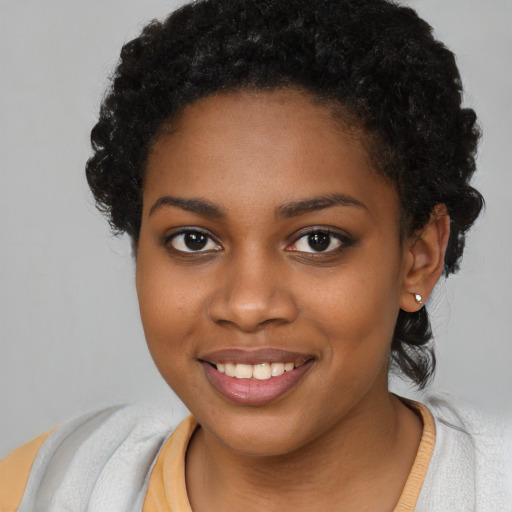 Joyful black young-adult female with short  brown hair and brown eyes
