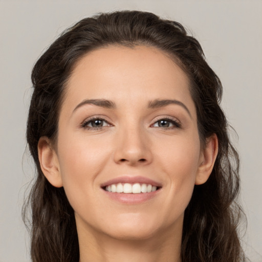 Joyful white young-adult female with long  brown hair and brown eyes