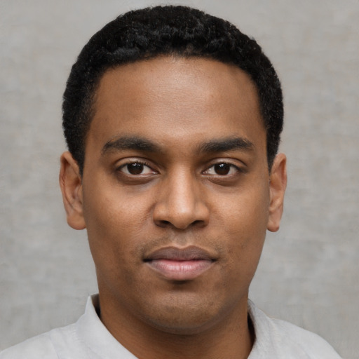 Joyful black young-adult male with short  black hair and brown eyes