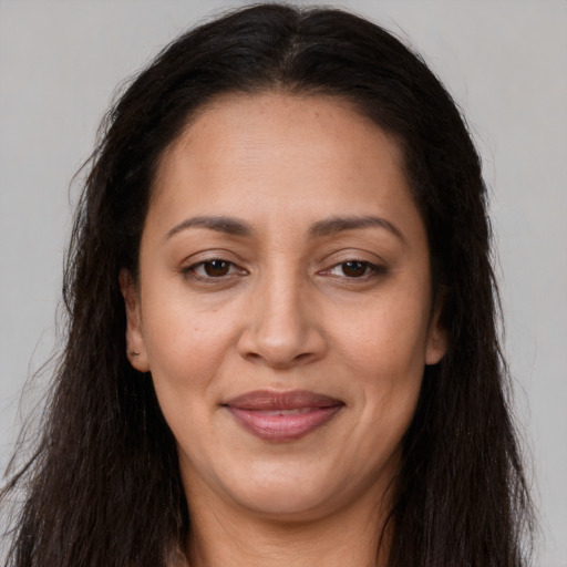 Joyful latino adult female with long  brown hair and brown eyes