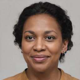 Joyful black adult female with medium  brown hair and brown eyes