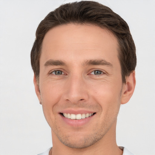 Joyful white young-adult male with short  brown hair and grey eyes